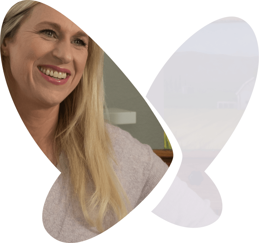 Jennie, a XYWAV patient, wearing a white top and smiling